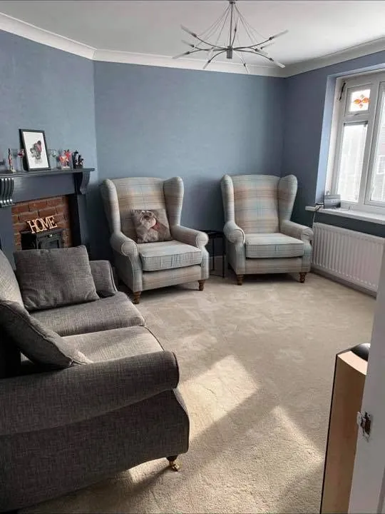 The same living room after decorating, painted in soft blue grey with the chimney breast made good