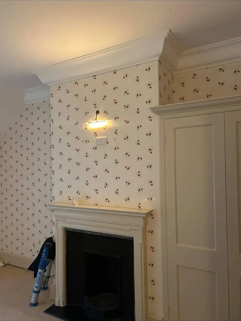 Chimney breast and alcoves papered and painted around a cast iron fireplace