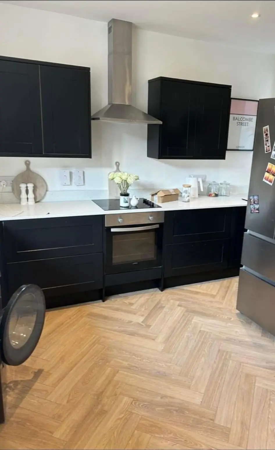Kitchen cabinets resprayed in deep navy above a herringbone wood floor in Andover