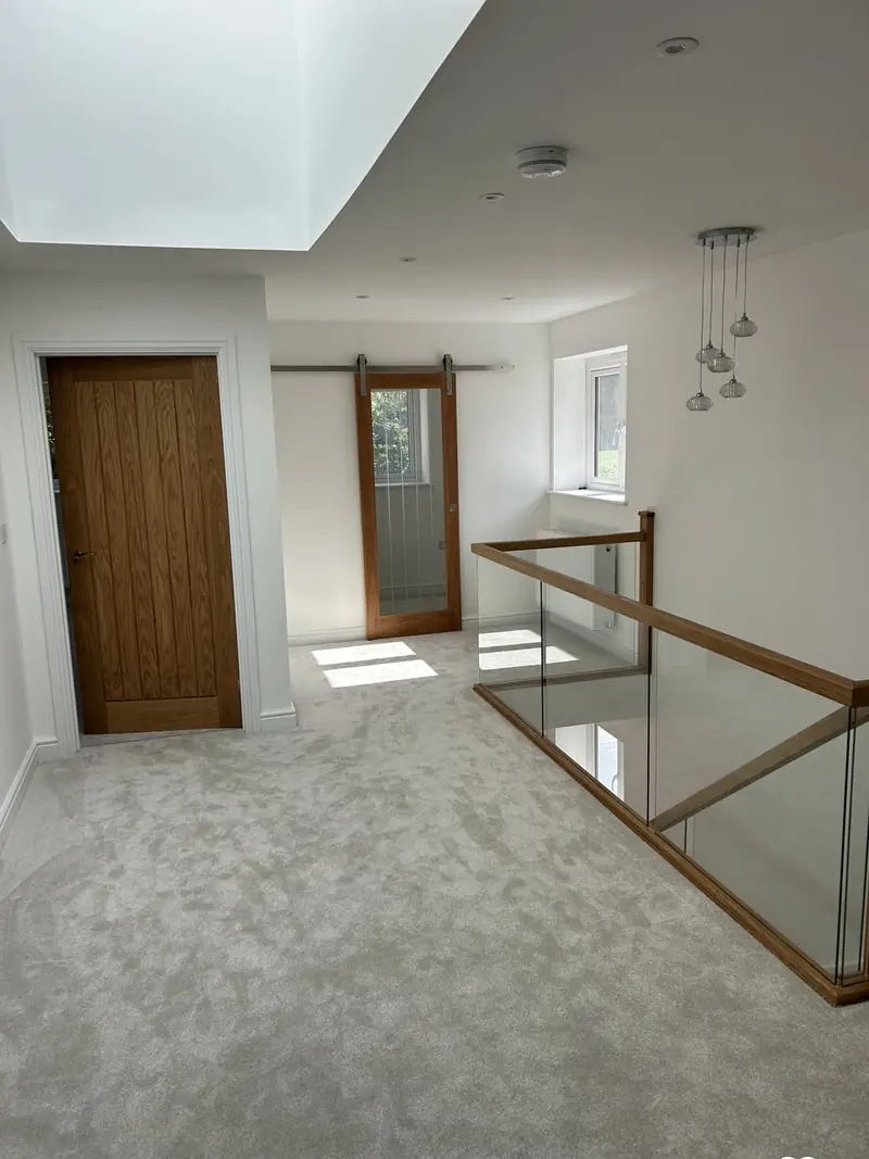 Galleried landing decorated in soft white with oak doors and a glass balustrade