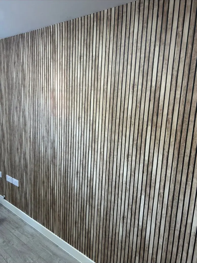 Textured vertical grain wallpaper hung across a full wall with a seamless pattern match