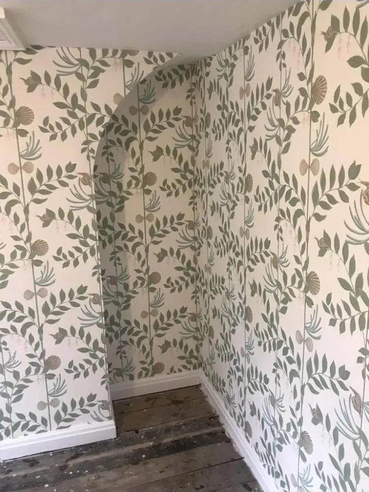 Trailing leaf wallpaper taken around a corner and finished neatly down to new flooring