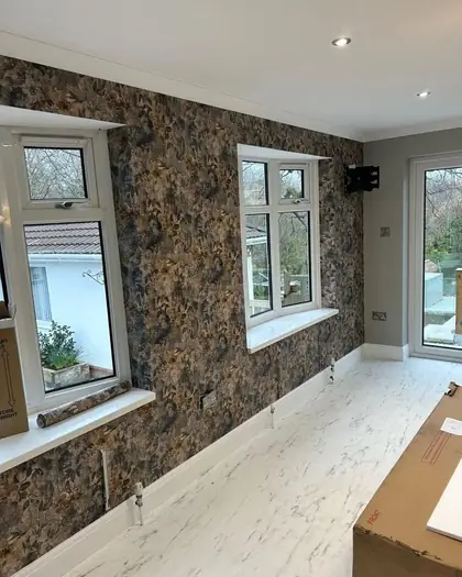 Dark floral wallpaper hung across a bedroom wall